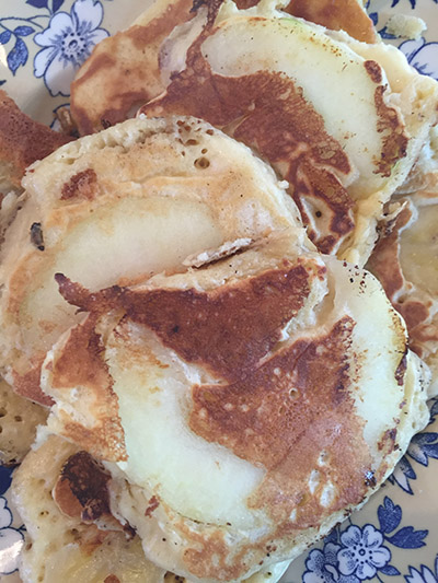 Pikelets with slices of apple.